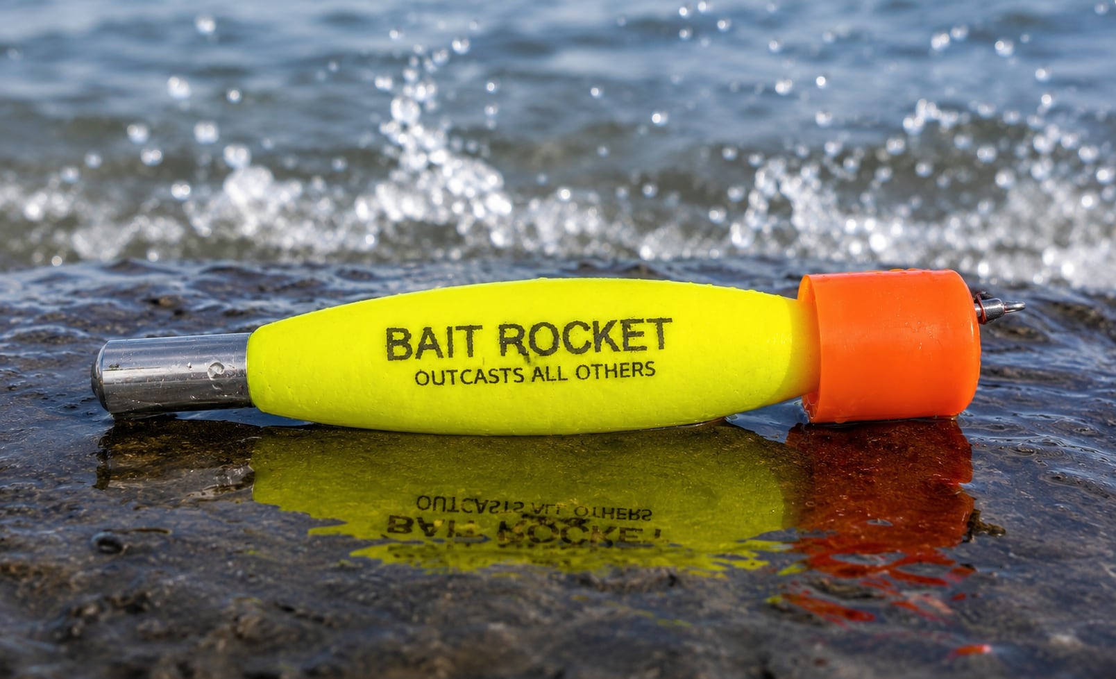 A hi-vis yellow Bait Rocket™ float with an orange popper cap riding in the water — BAIT ROCKET, OUTCASTS ALL OTHERS stamped on the body, splash kicking up behind it.